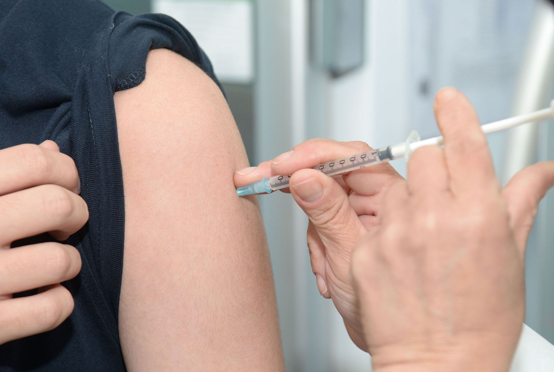 a person being injected in the arm with a needle